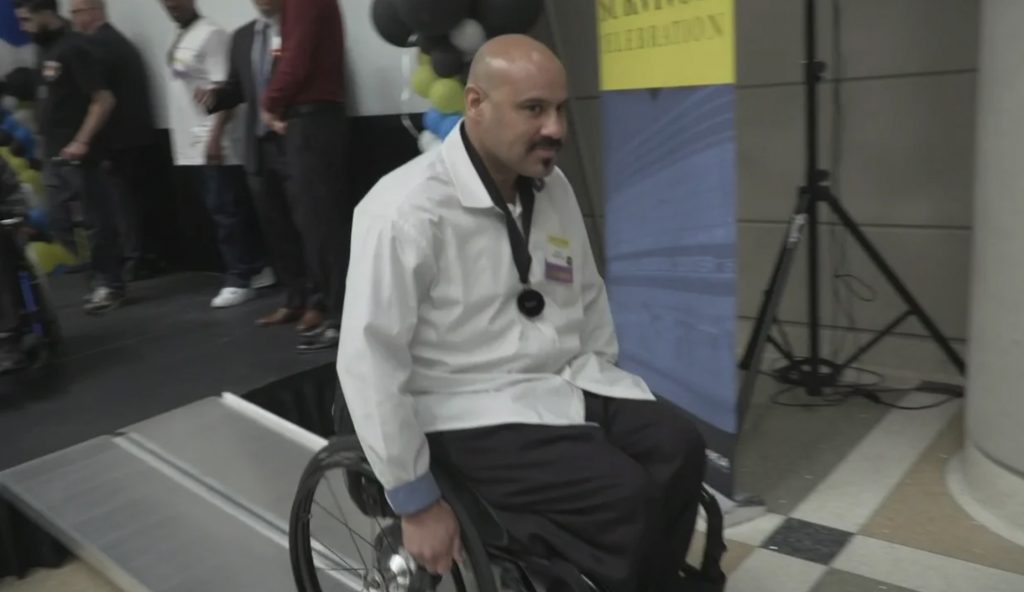 A healthcare professional in a wheelchair participating in a community celebration event.