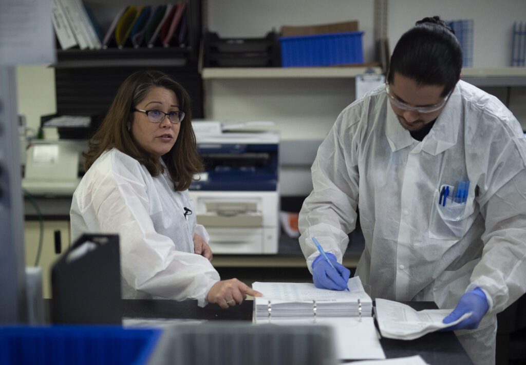 Dr. Nicole Green, Public Health Laboratories Director, visits with staff as they process PCR test for COVID-19 at maximum capacity on March 19, 2020. ( Photo Credit: Los Angeles County )